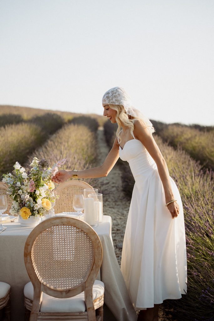 Mariée près d’une table décorée dans un champ de lavande
