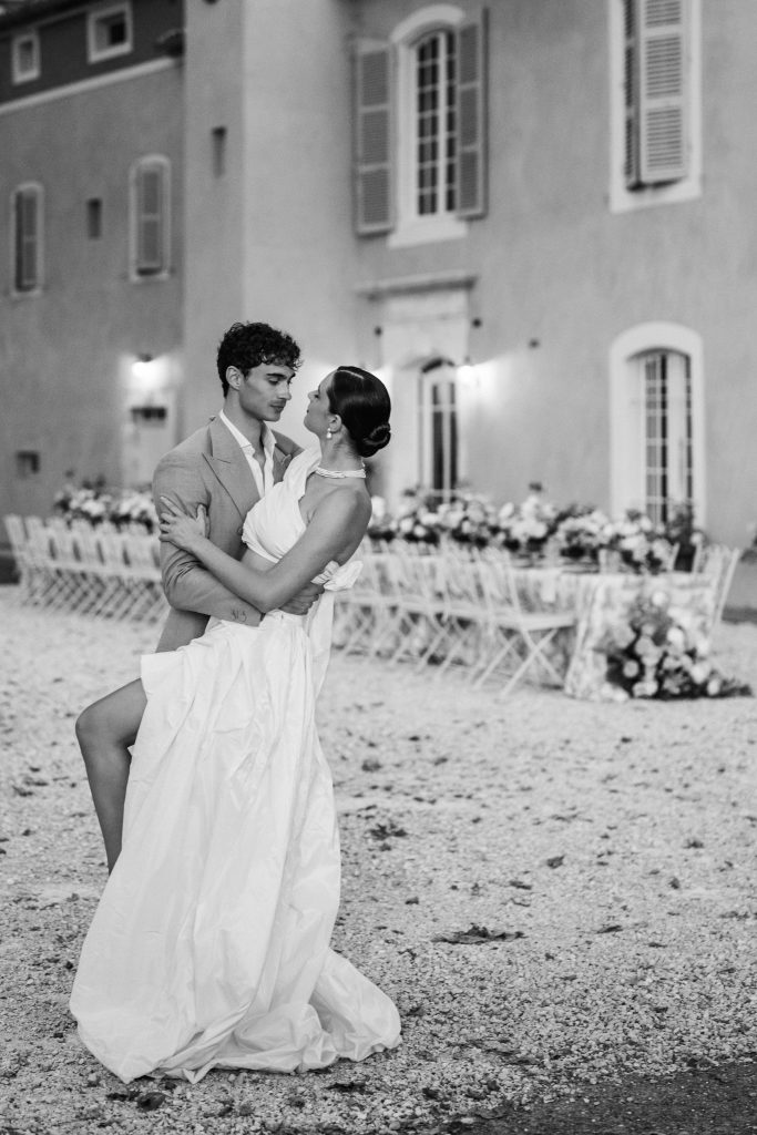 Couple de mariés devant une longue table de mariage décorée en Provence
